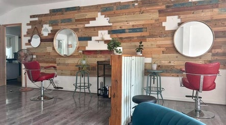 Chic interior of Tracey Jack Hair at Evolve in Newquay, England, GB with rustic mirrors and red chairs.