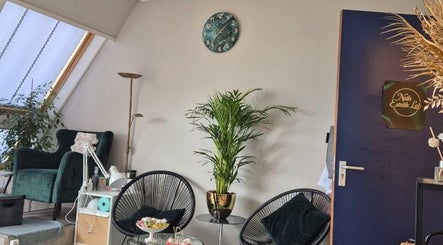Современный интерьер NailsEstetikLab в Лейдердорпе, Zuid-holland, NL с зелёным креслом и растениями.