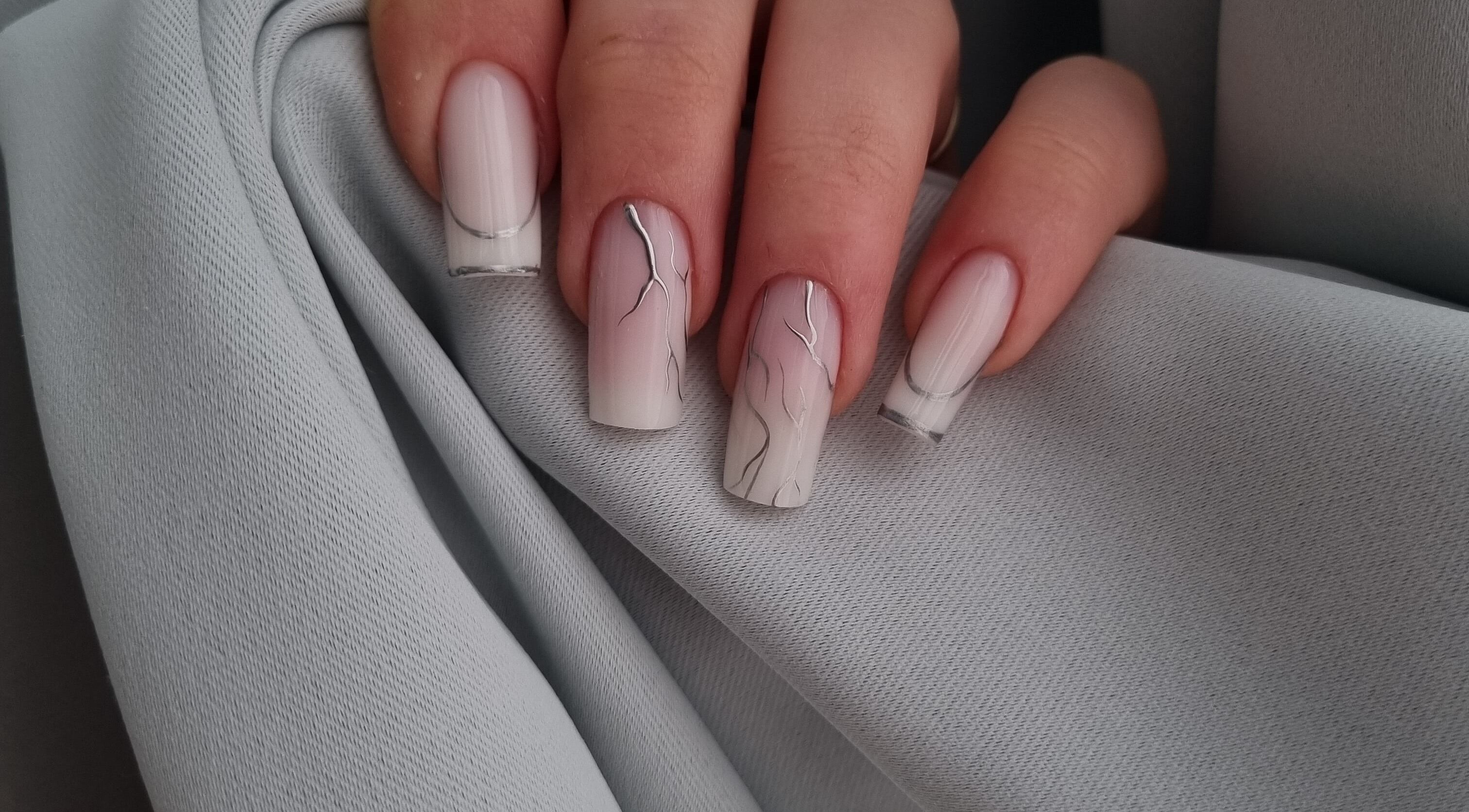 Elegant nagelontwerp bij Glossy Nails Art, Leiden, Zuid-holland, NL, met subtiele zilveren accenten.