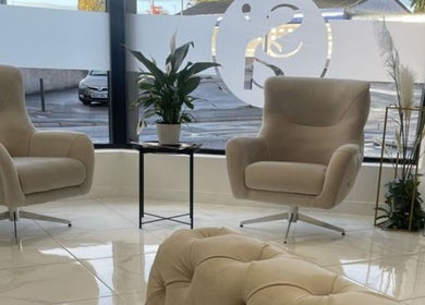 Sophisticated interior at EJ Hair Clinic in Keynsham, England, GB with beige chairs and a potted plant.