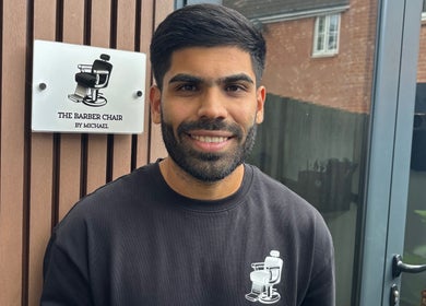 Smiling barber at The Barber Chair By Michael, Wainscott, England, GB.