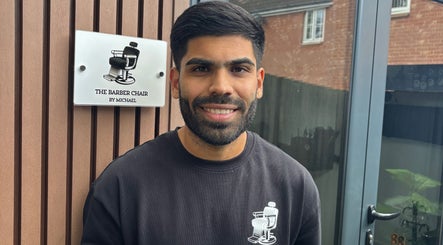 Smiling barber at The Barber Chair By Michael, Wainscott, England, GB.