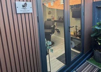 Entrance to The Barber Chair By Michael, Wainscott, England, GB, showing a stylish interior with modern decor.