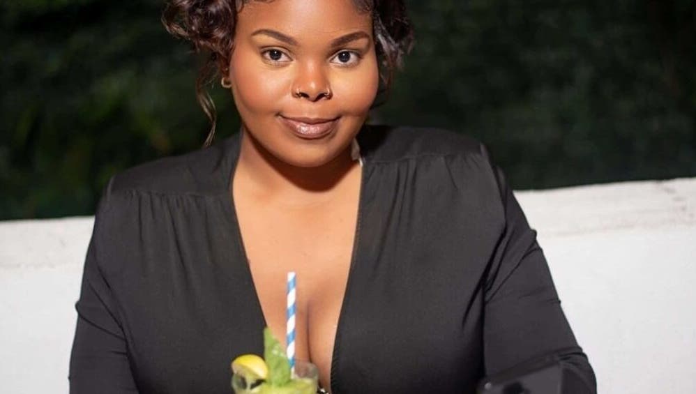 Woman enjoying a refreshing drink at Flawless Finish by Tashii, Kingston, St. Andrew Parish, JM.