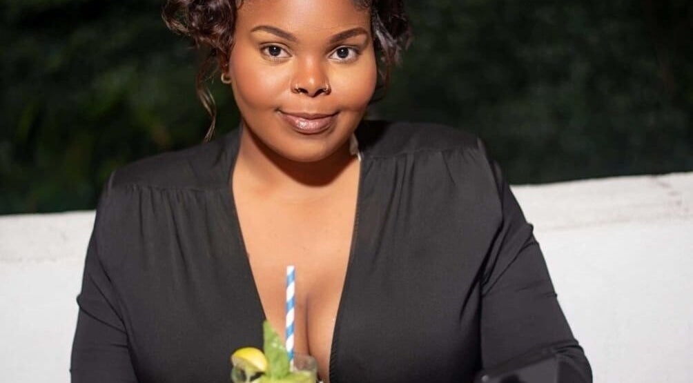 Woman enjoying a refreshing drink at Flawless Finish by Tashii, Kingston, St. Andrew Parish, JM.