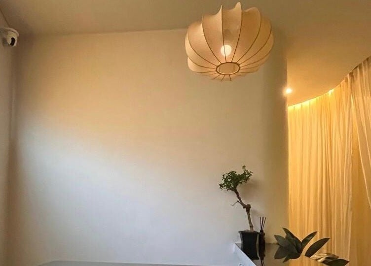 Tranquil spa room with bamboo lighting at Luminee Spa, Bali, Bali, ID. Elegantly draped curtains enhance relaxation.