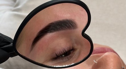 Eyebrow reflection in heart-shaped mirror at Left & Right Beauty, Colchester, England, GB.