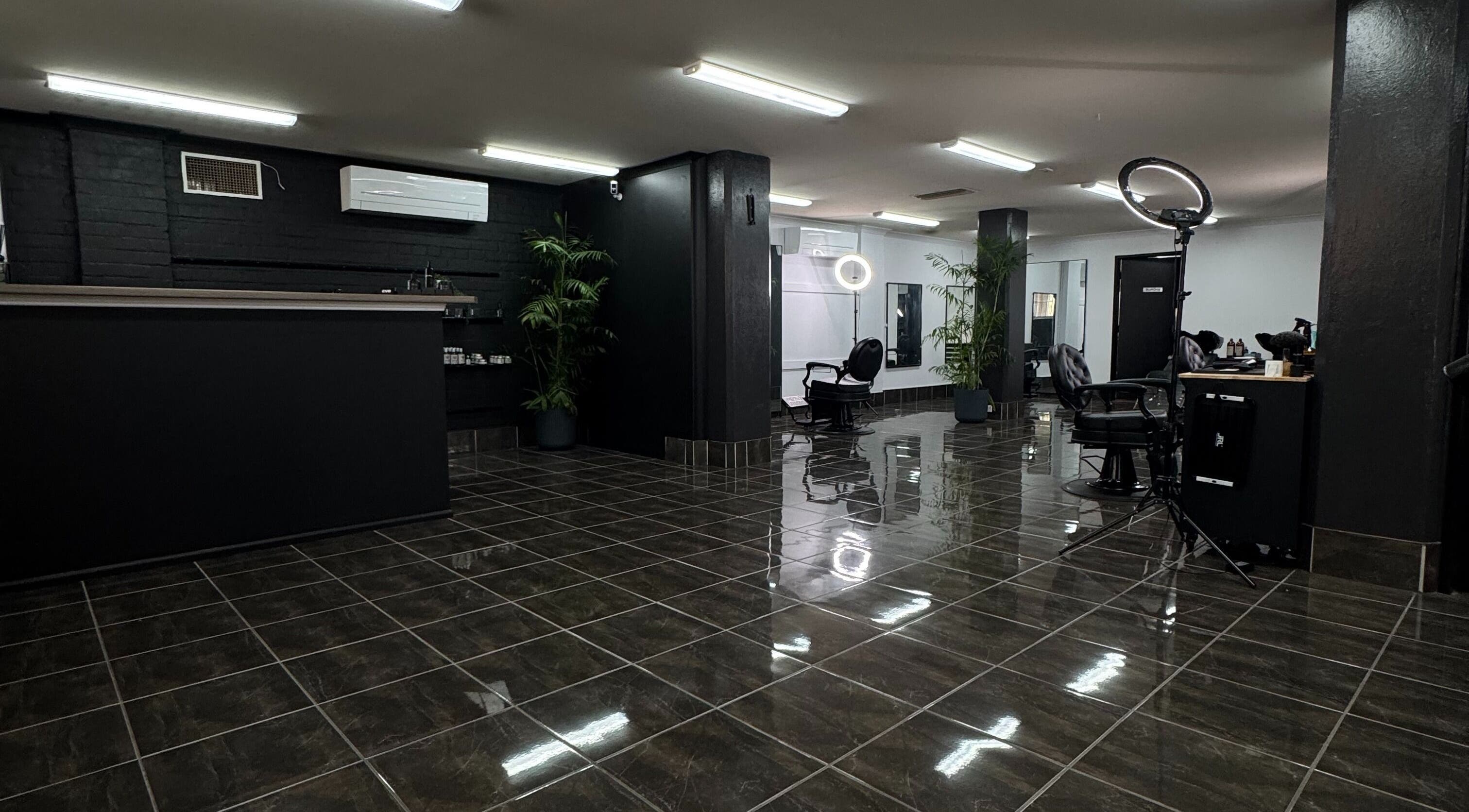 Modern interior of Collective Vision Barbers in Gladstone Central, Queensland, AU, featuring stylish chairs and decor.
