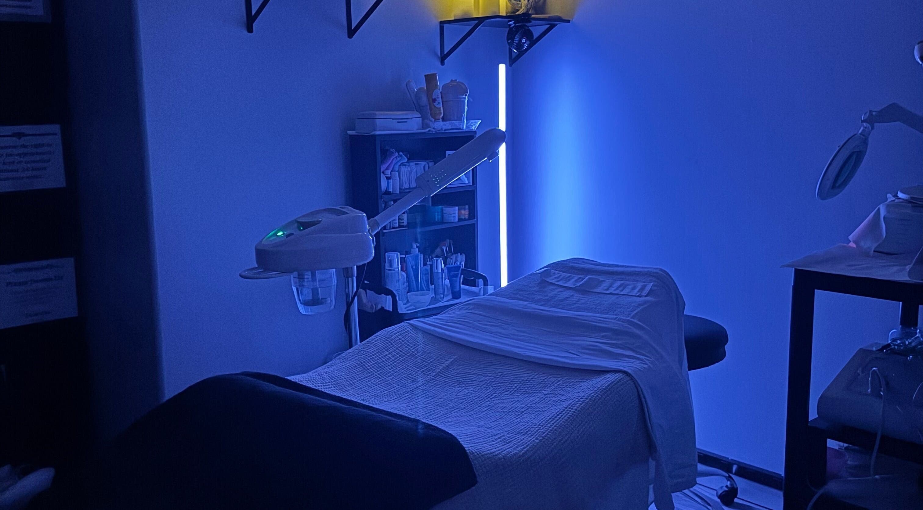 Relaxing treatment room at Autumn Essence Esthetics, Brigham City, Utah, US, with calming blue lighting.