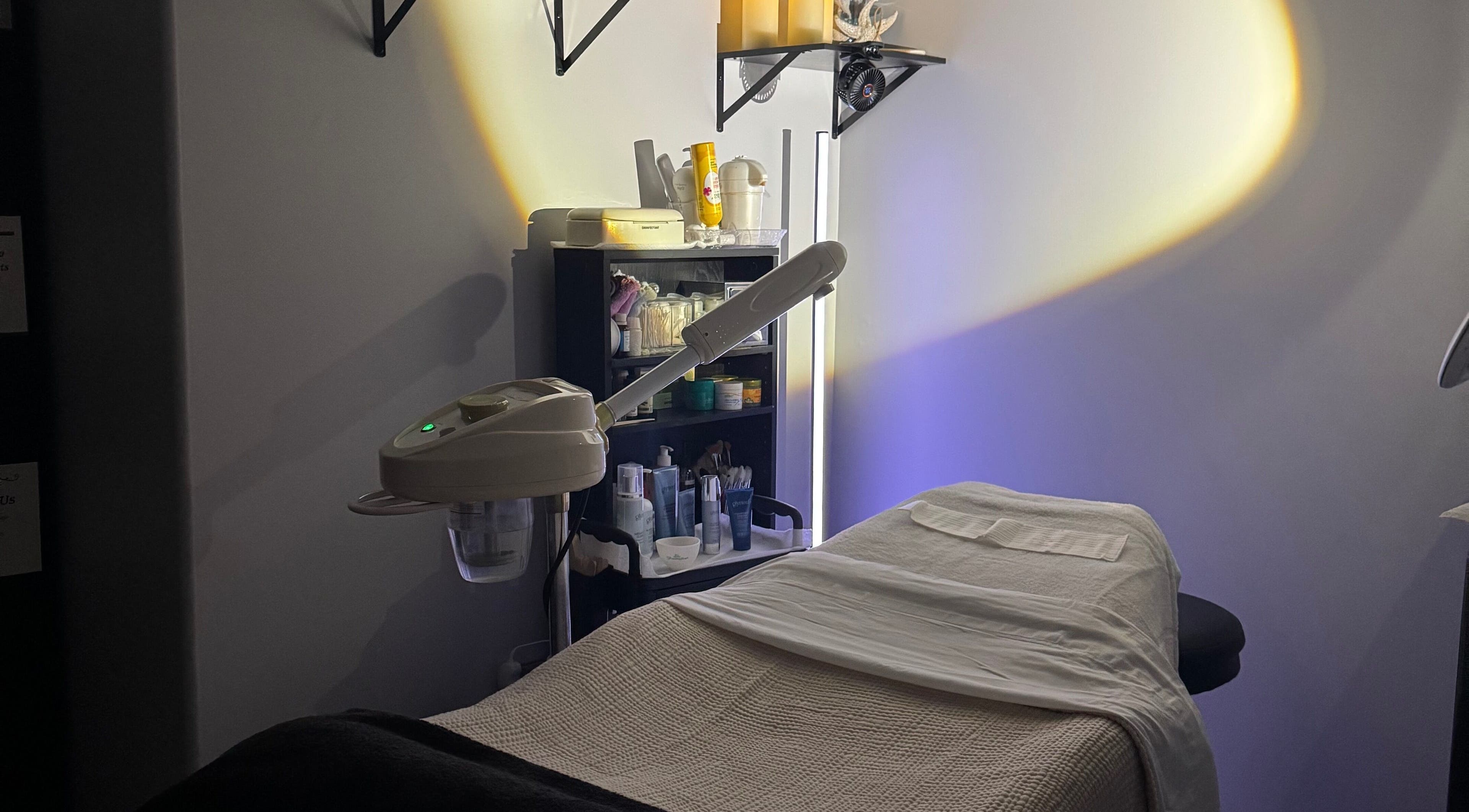 Serene treatment room at Autumn Essence Esthetics in Brigham City, Utah, US, with ambient lighting and skincare equipment.