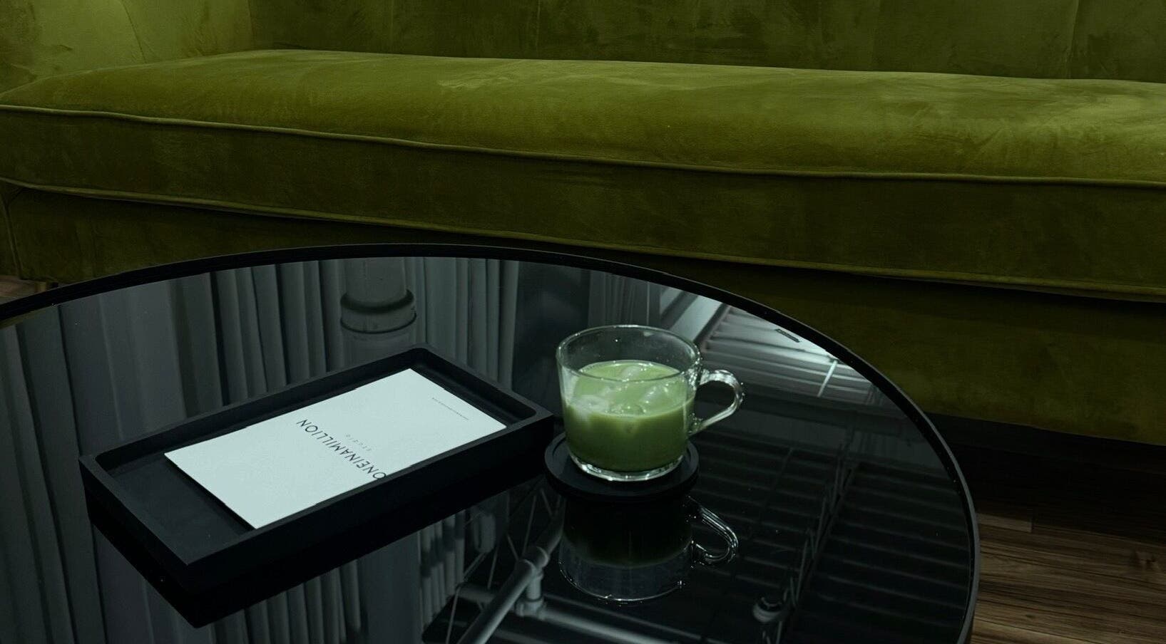 Stylish green sofa and table at The Twins Lounge, Montréal, Québec, CA with a refreshing matcha drink.