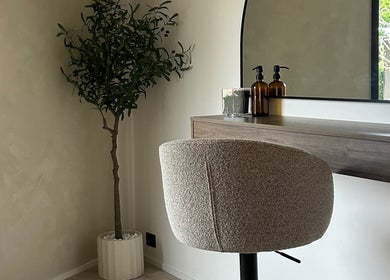 Stylish salon setup at By Lily Rose, Menai, New South Wales, AU with modern chair, desk, and potted plant.