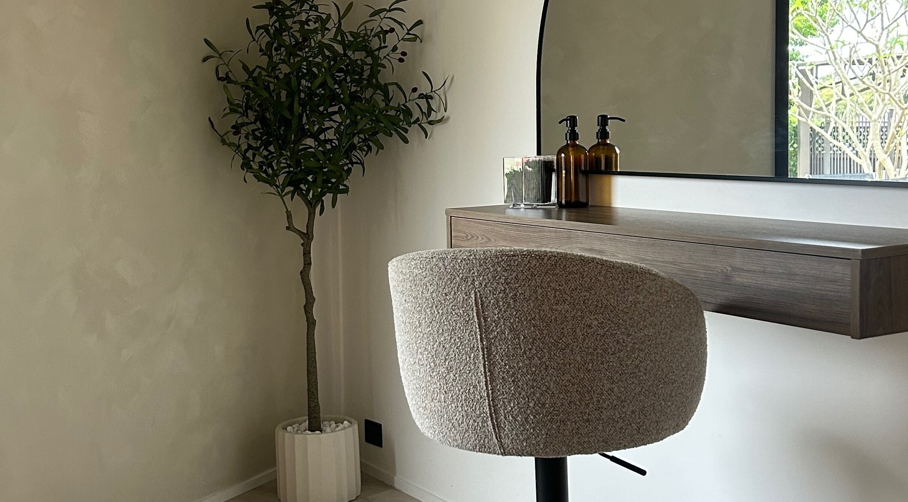 Stylish salon setup at By Lily Rose, Menai, New South Wales, AU with modern chair, desk, and potted plant.