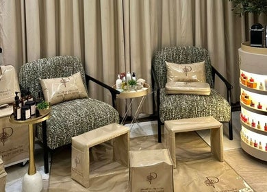 Chic seating area at Peony Beauty Center Kalba, Kalba, Sharjah, AE, showcasing products and comfortable chairs.