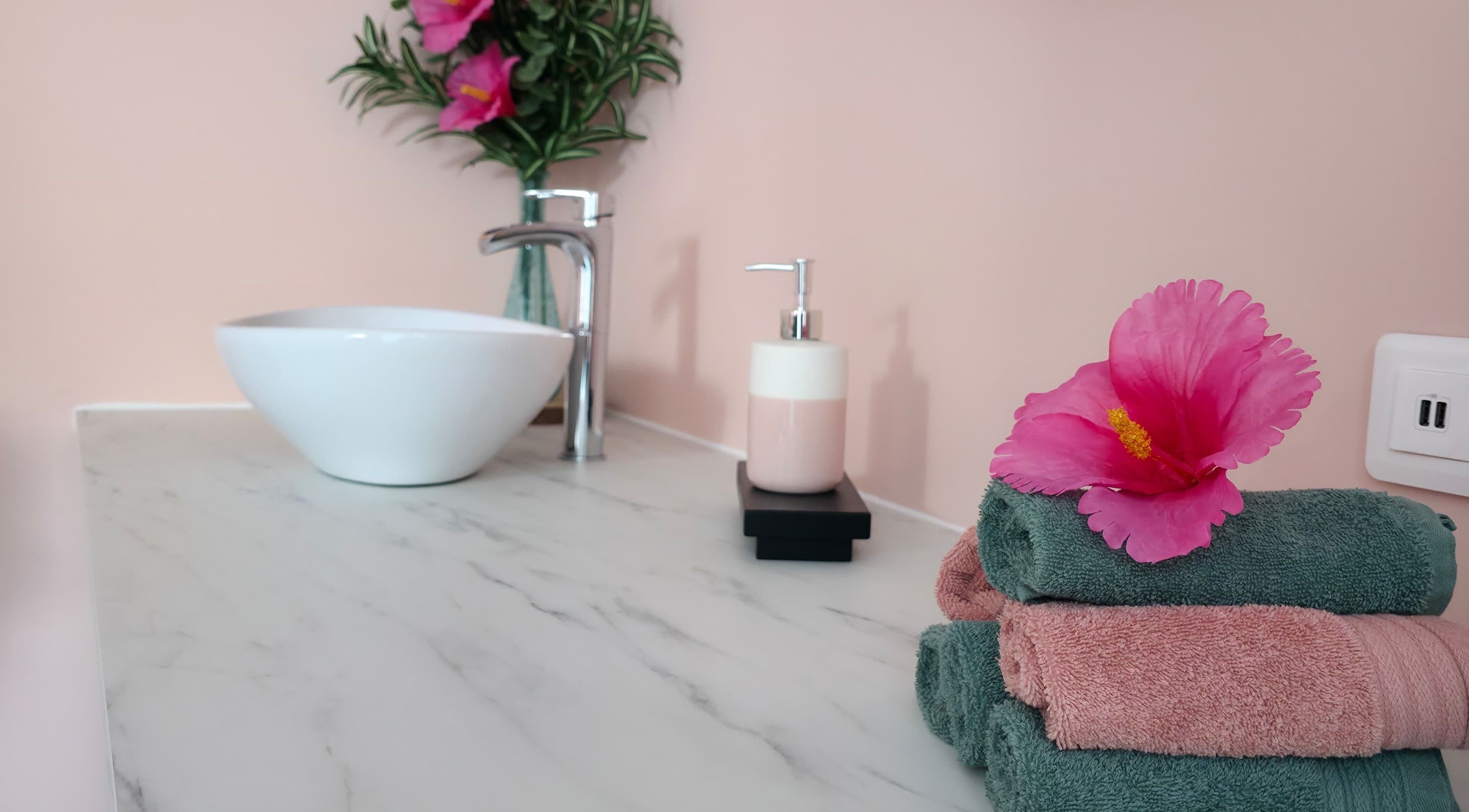 Espace de bien-être chez Clem's beauty à Rouen, Normandie, FR avec serviettes et fleurs exotiques.