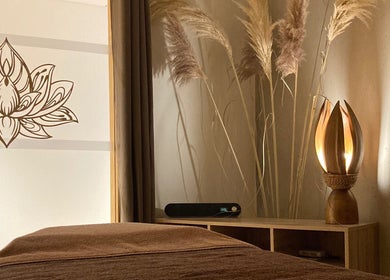 Salle de relaxation sereine chez Ô’tant Pour Soi à Perpignan, Occitanie, FR, avec lampe unique et décor fleuri.