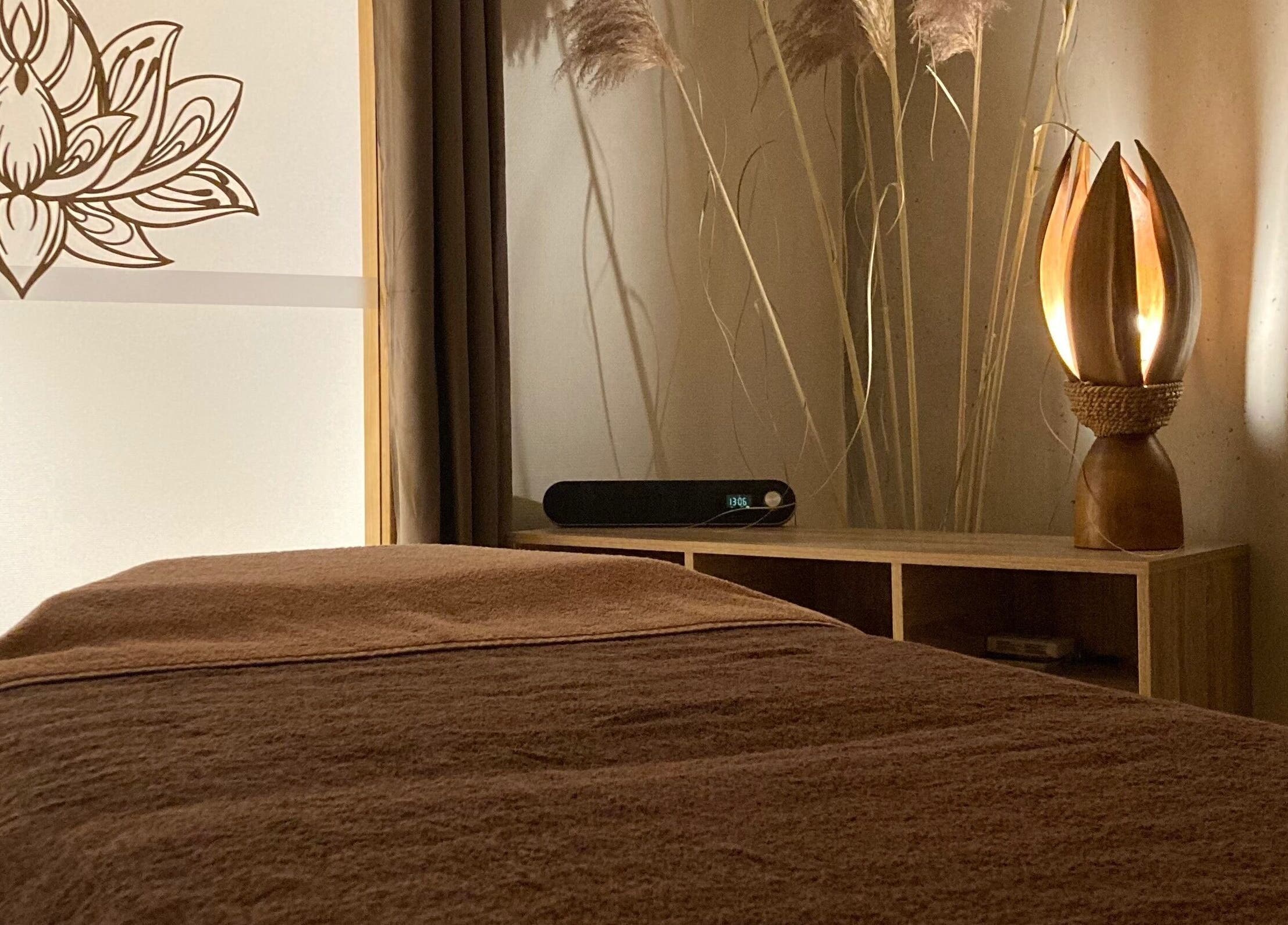 Salle de soin relaxante à Ô’tant Pour Soi, Perpignan, Occitanie, FR, avec table de massage et lampe décorative.