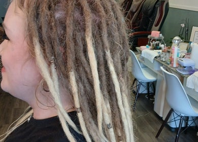 Stylish dreadlocks hairstyle at Spa De Unique, Tillsonburg, Ontario, CA with elegant workspace in background.