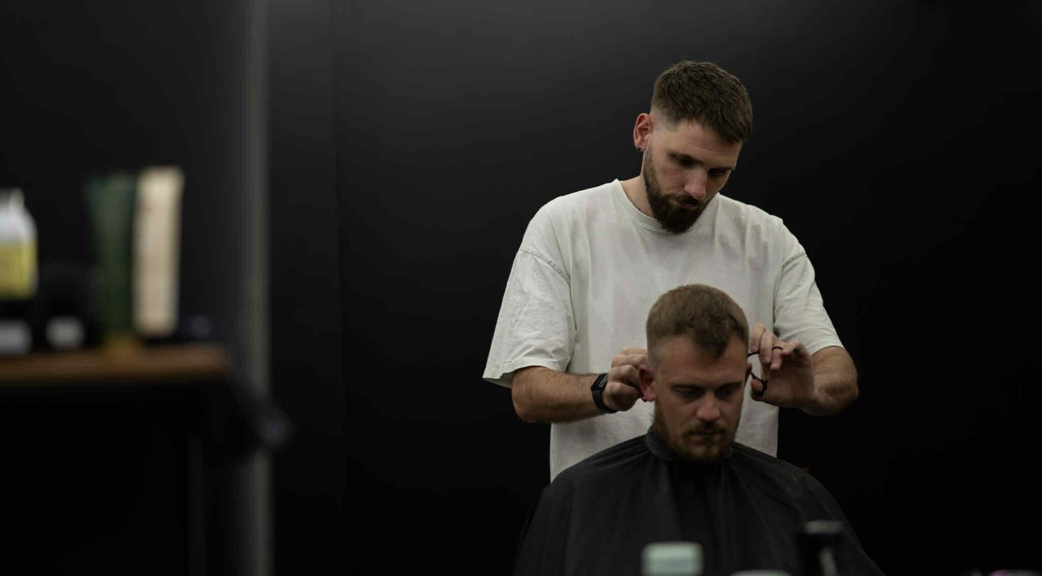 Coiffeur à SNOW BARBER, Haguenau, Grand Est, FR, réalisant une coupe précise.