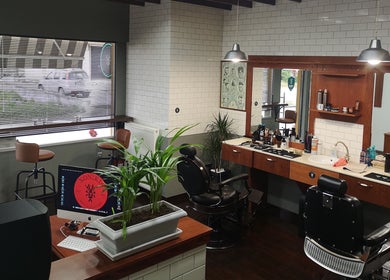 Εσωτερικό του Xonikis Men’s Hair Studio, Μεγάλη Παναγία, GR, με καρέκλες κοπής και προϊόντα περιποίησης.