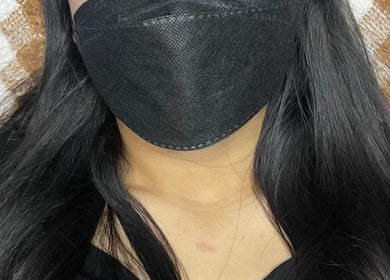 Guest with flowing black hair enjoys a facial mask at Rein.House beauty, Bali, Bali, ID.
