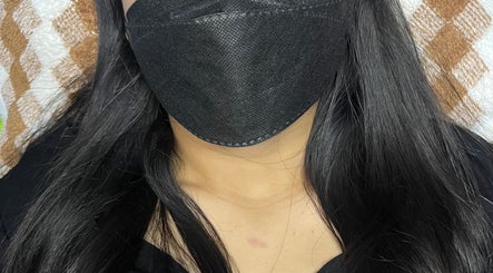 Guest with flowing black hair enjoys a facial mask at Rein.House beauty, Bali, Bali, ID.