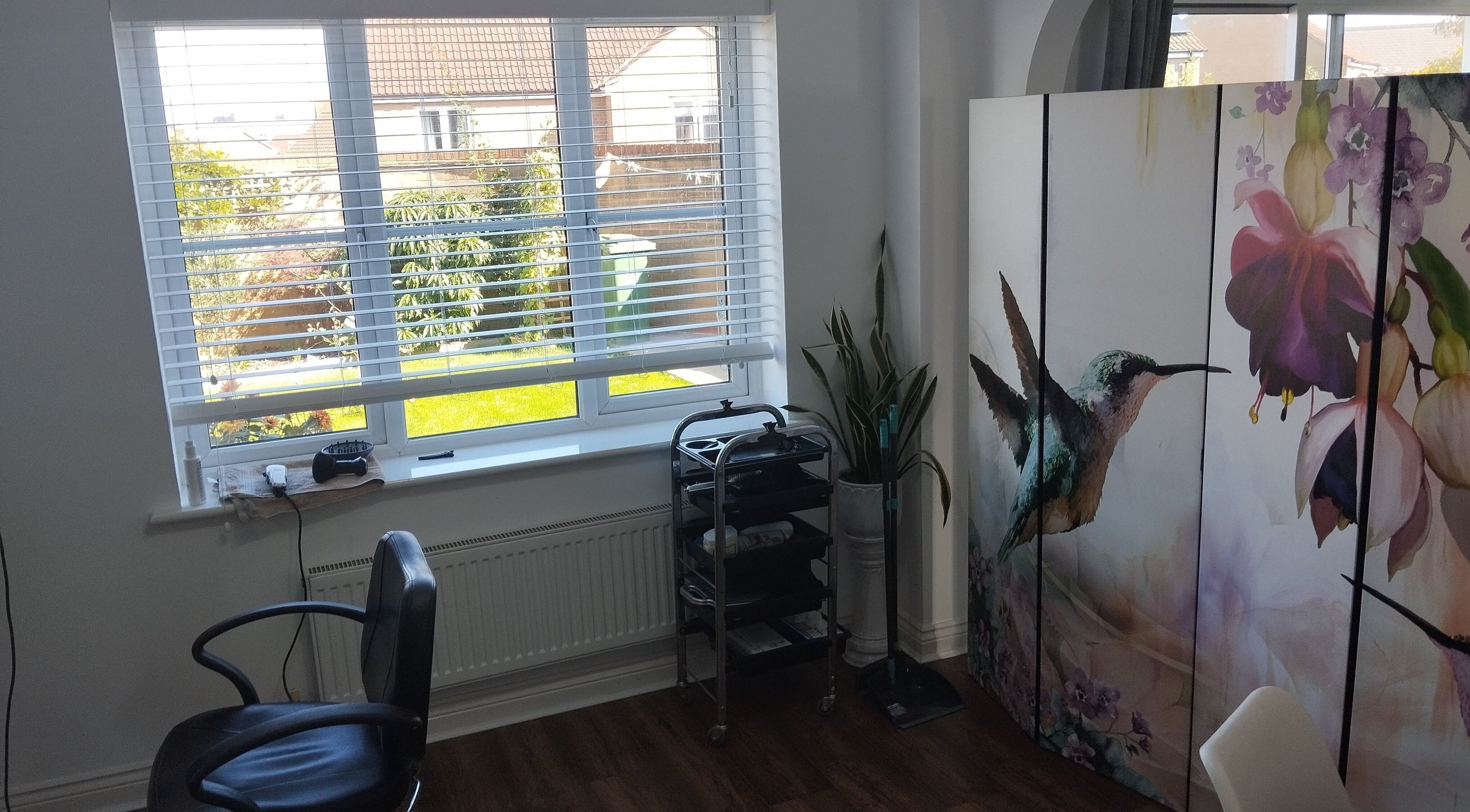 Stylish window in Leigh's hair salon, Bridgwater, England, GB, with floral decor and sleek equipment.