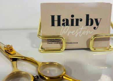 Gold scissors beside Hair by Preston's sleek cardholder in Taunton, England, GB.