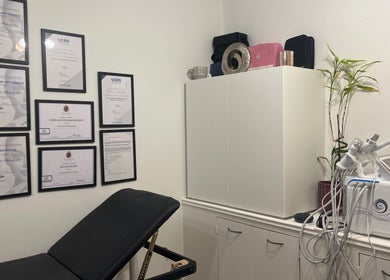 Calming treatment room at Naz Aesthetics, Manchester, England, GB, featuring certificates and advanced equipment.