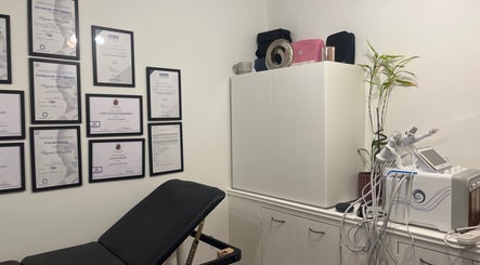 Calming treatment room at Naz Aesthetics, Manchester, England, GB, featuring certificates and advanced equipment.