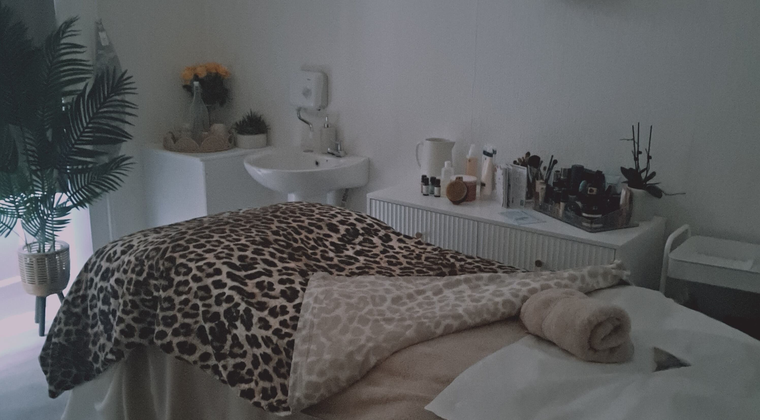 Cozy treatment room at Comfort Zone Beauty Therapy, Wetherby, England, showcasing a bed with a leopard print cover.