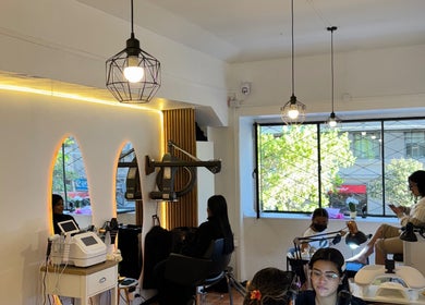 Interior de FR en Santiago, Región Metropolitana, CL, mostrando clientes disfrutando servicios de belleza.