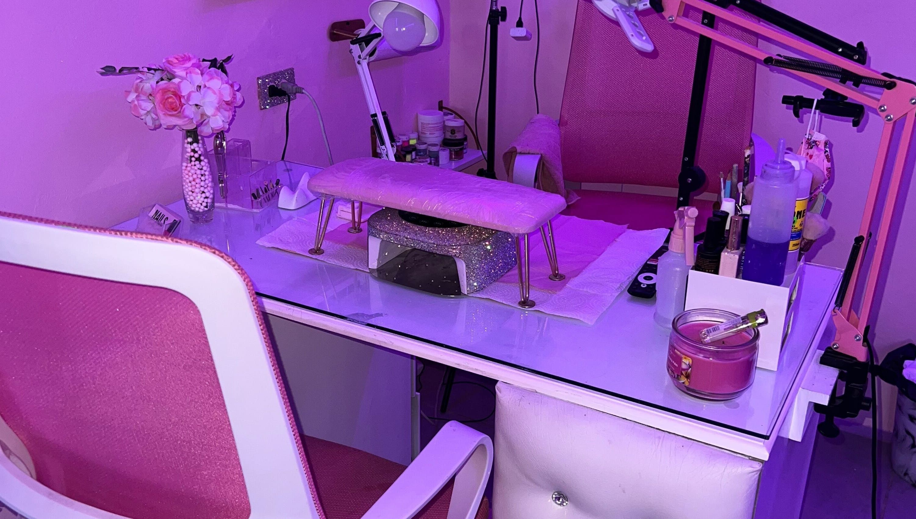Nail station with pink decor at BlingQueen Beauty Bar in Enterprise, Chaguanas, TT under purple lighting.