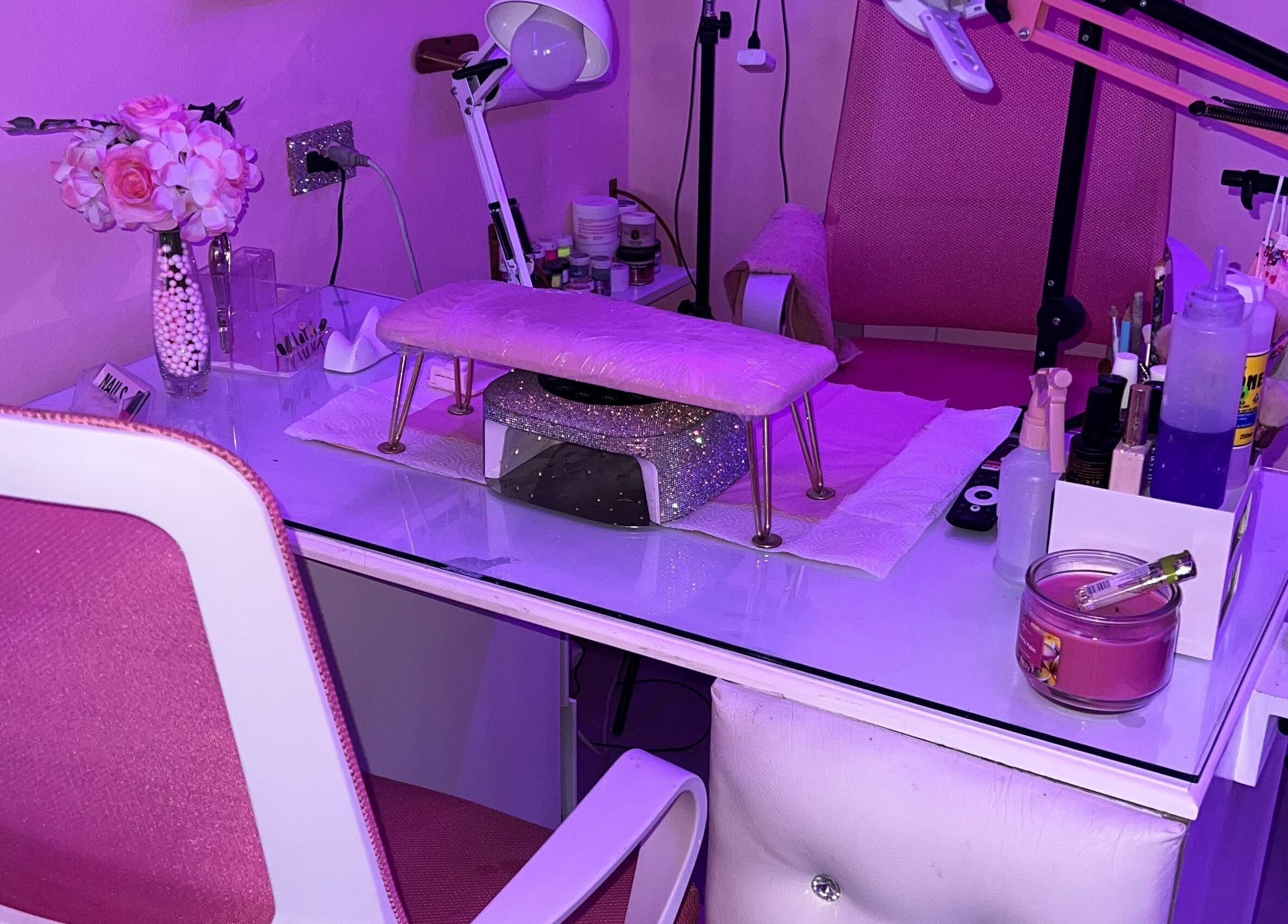 Nail station with pink decor at BlingQueen Beauty Bar in Enterprise, Chaguanas, TT under purple lighting.