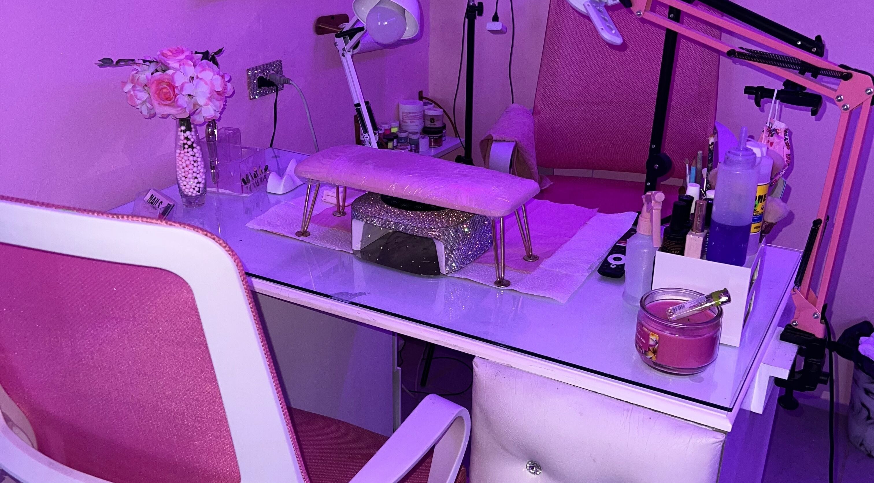 Nail station with pink decor at BlingQueen Beauty Bar in Enterprise, Chaguanas, TT under purple lighting.