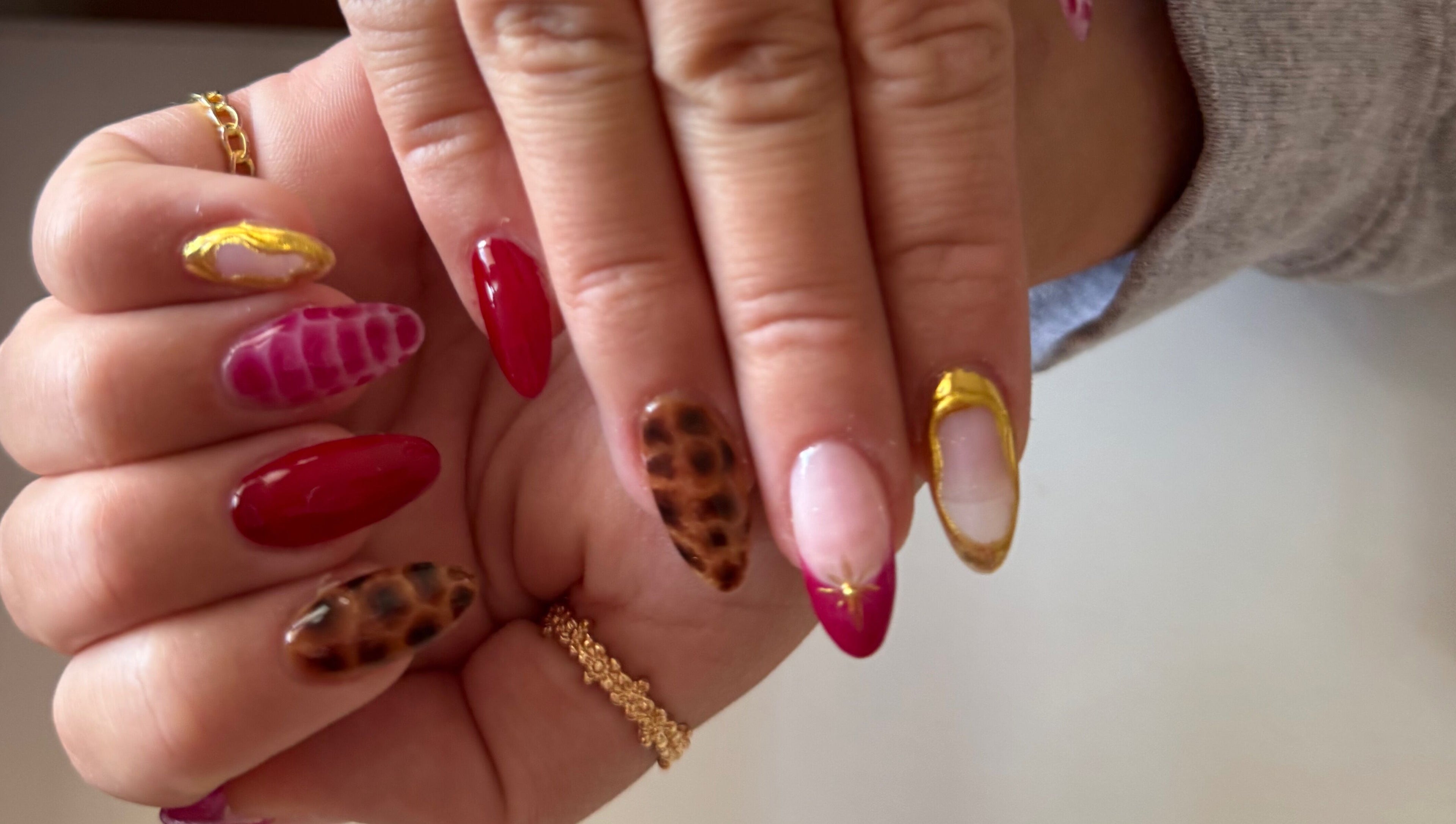 Stylish nail art designs at Melia Nailed It in Tucson, Arizona, US featuring gold accents and animal print.