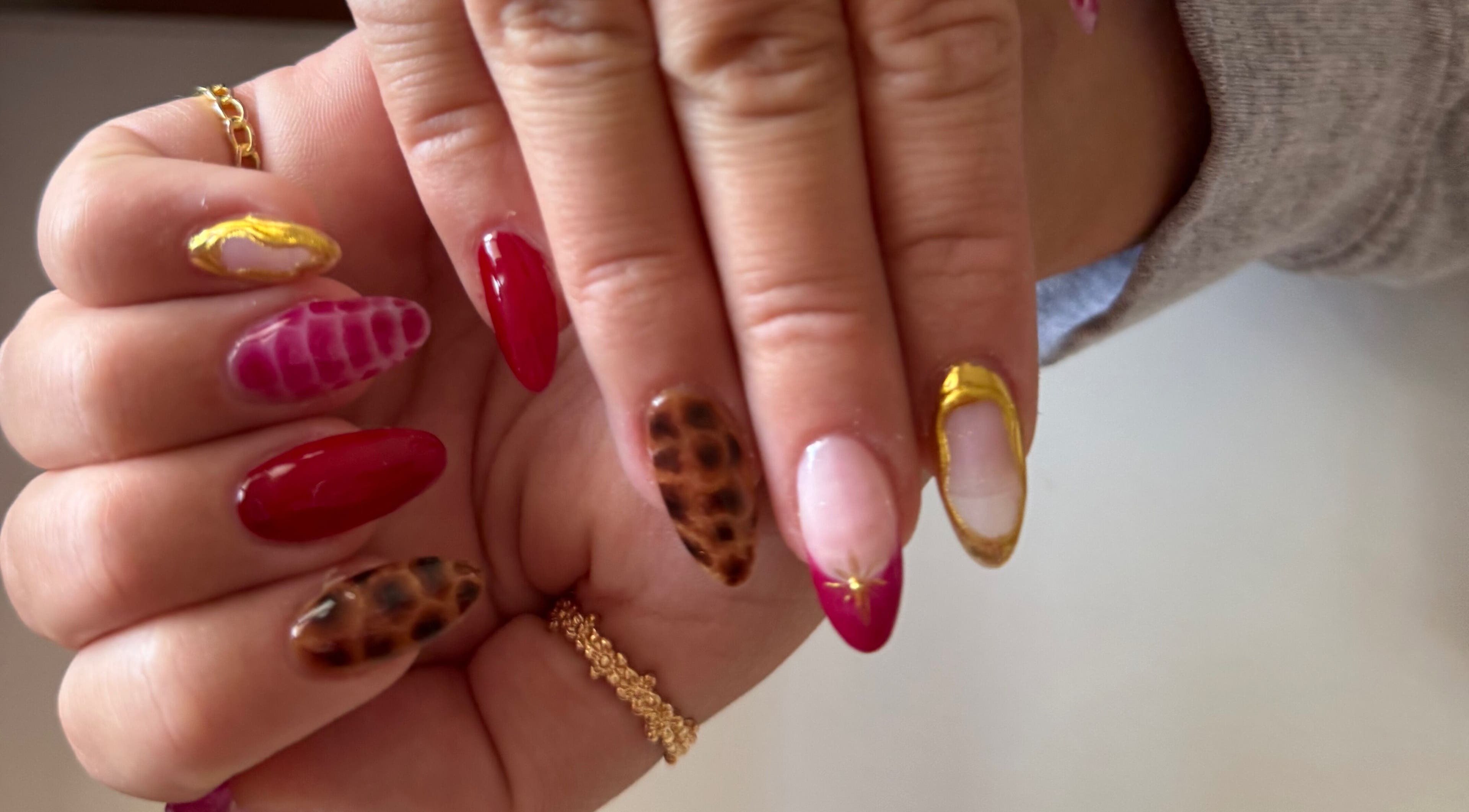 Stylish nail art designs at Melia Nailed It in Tucson, Arizona, US featuring gold accents and animal print.