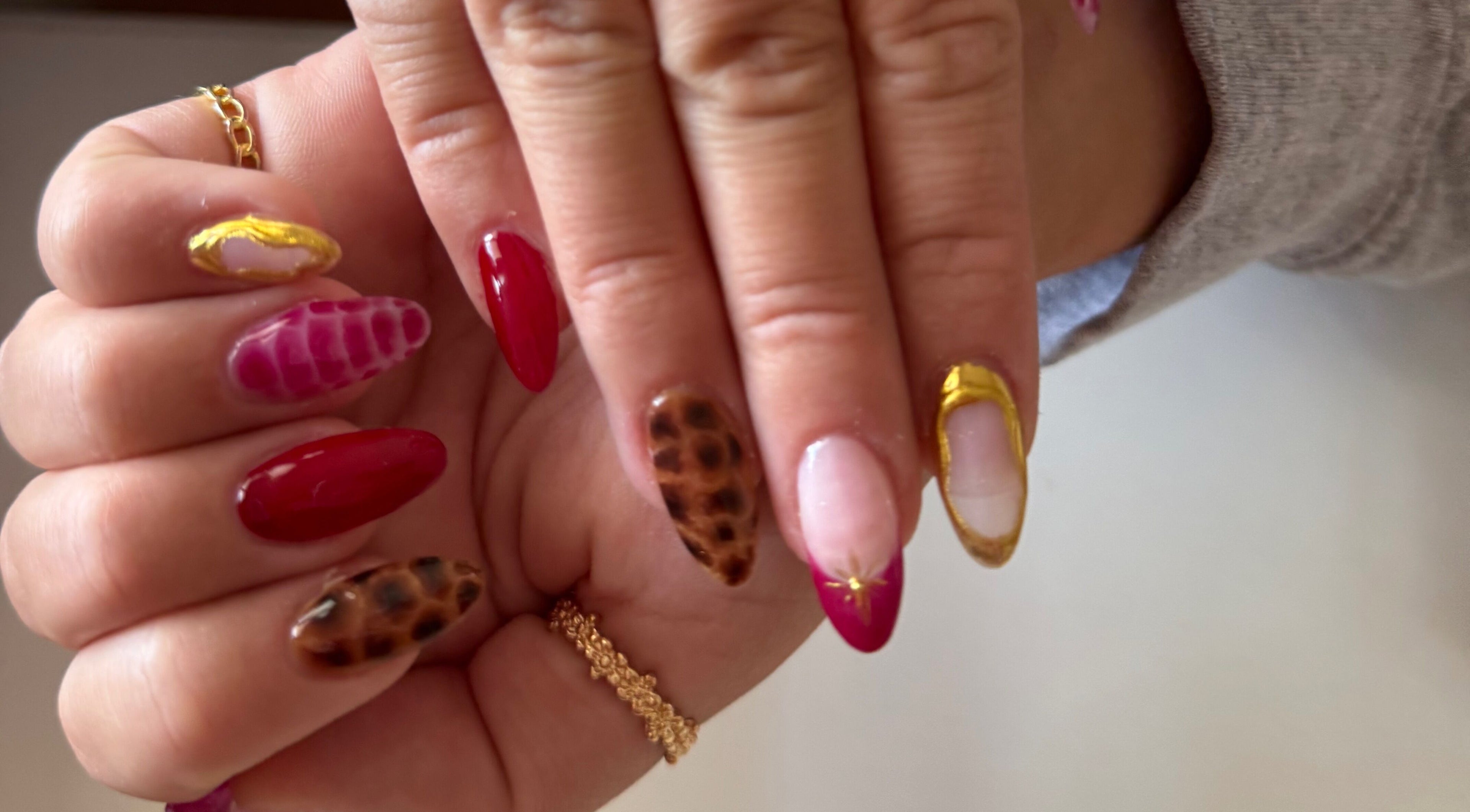 Stylish nail art designs at Melia Nailed It in Tucson, Arizona, US featuring gold accents and animal print.