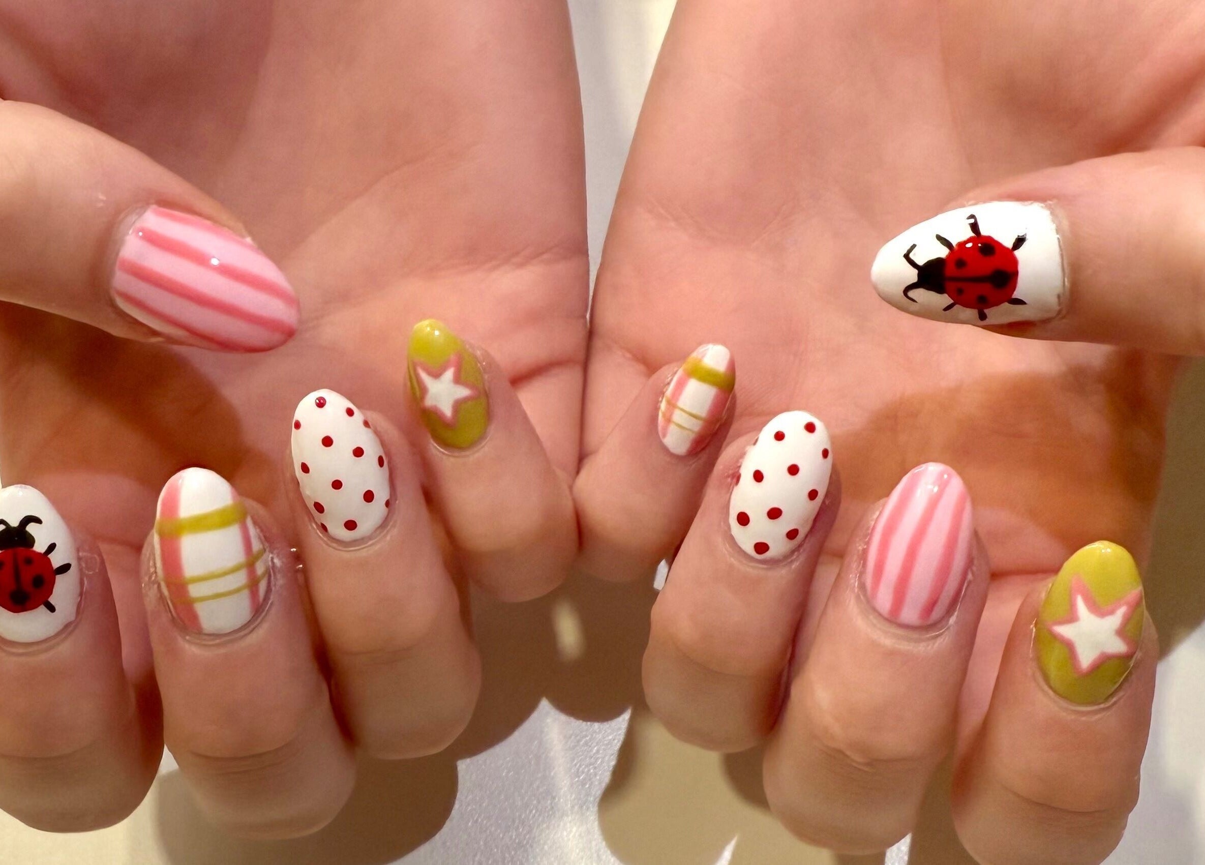 Colorful nail art with ladybugs and stripes by Melia Nailed It, Tucson, Arizona, US.