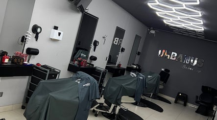Interior moderno de URBANUS BARBERÍA en La Ceja, Antioquia, CO con decoración elegante y sillas cubiertas.