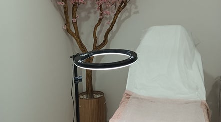 Espaço de estética Vânia Bessa em Paços De Ferreira, Porto, PT com cama de tratamento e decoração floral.