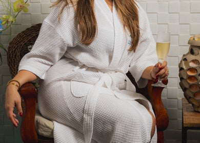 Relaxation at Purun Spa, Eagle, AW. Woman in robe with champagne in serene setting.