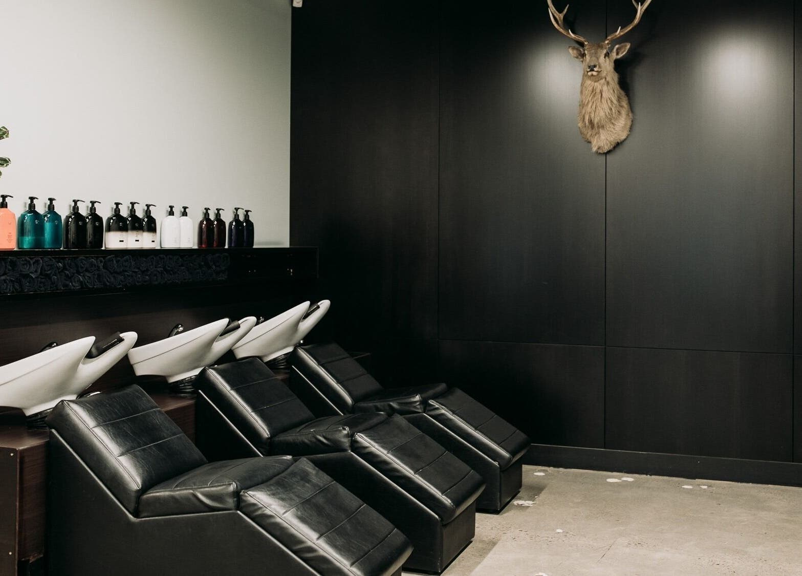 Elegant salon wash stations at Sable in Wellington, Wellington Region, NZ with modern black chairs and decor.