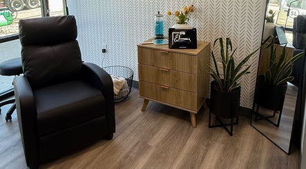 Relaxing corner at Elianna’s Beauty, Dallas, Texas with cozy chair, dresser, and plants.