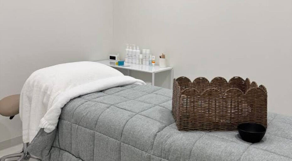 Cozy treatment room at Glow Aesthetics Collective, Ingle Farm, South Australia, AU with spa bed and wicker basket.