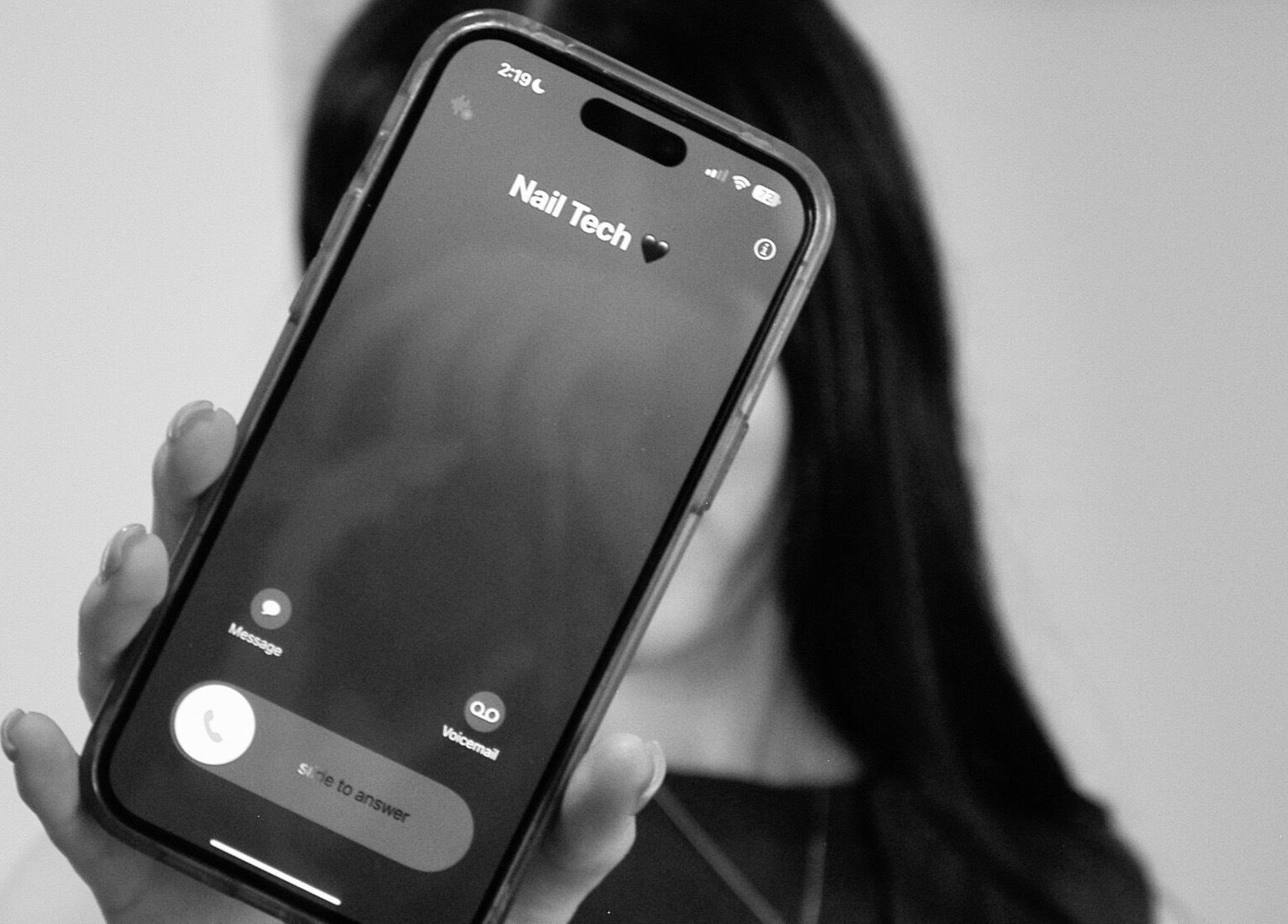 Person holding a phone displaying a nail tech contact at Lunar Beauty Collective, Thornton, New South Wales, AU.