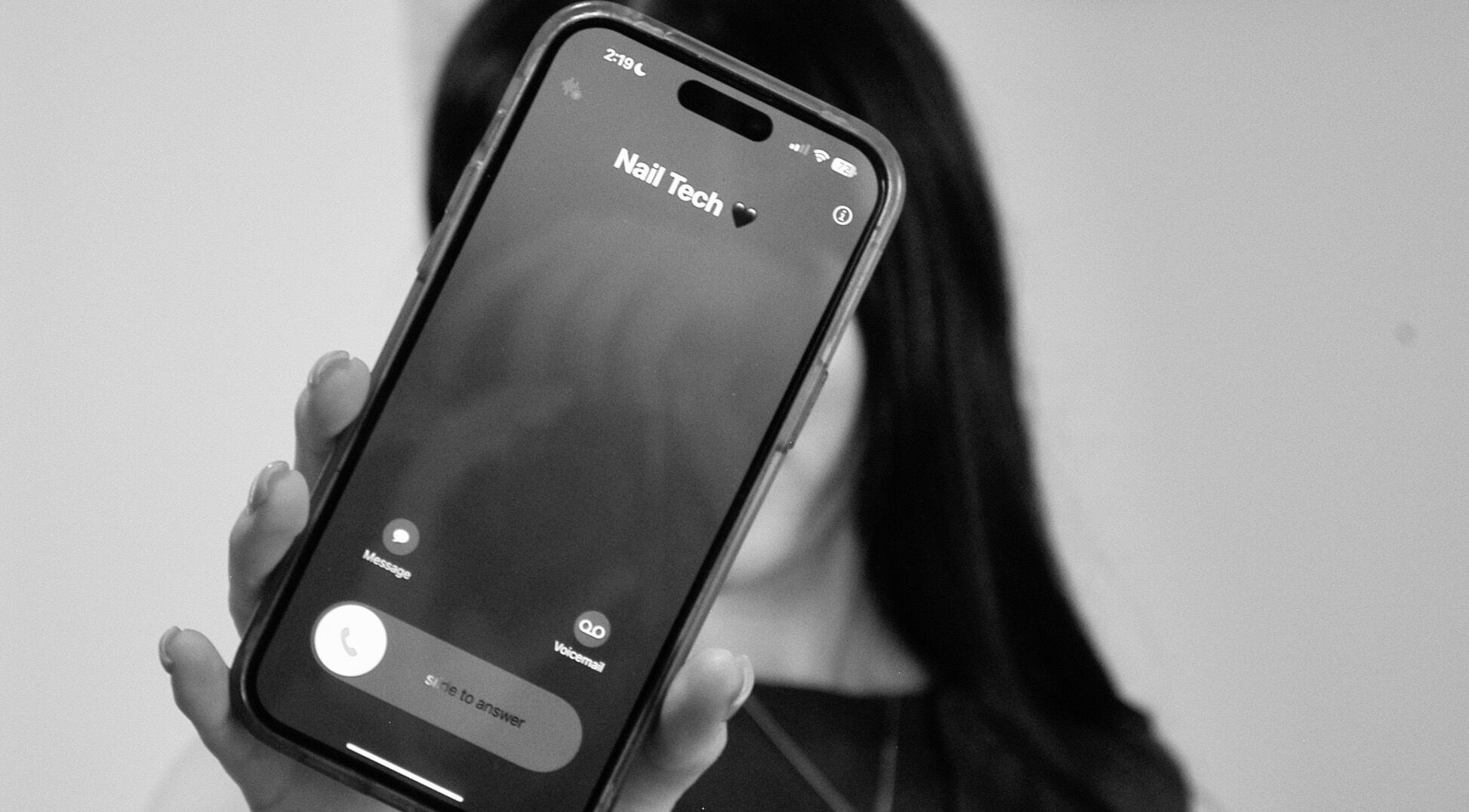 Person holding a phone displaying a nail tech contact at Lunar Beauty Collective, Thornton, New South Wales, AU.