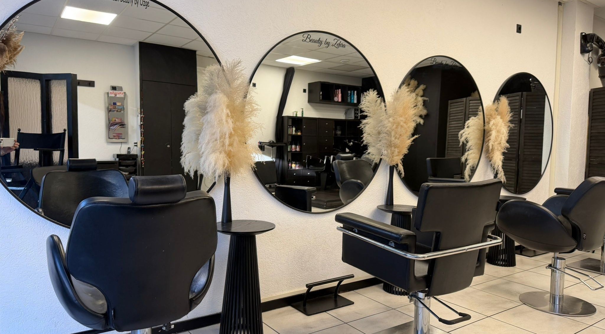 Elegante stylingstoelen bij Beauty by Ozge, Amsterdam, Noord-holland, NL met moderne spiegels.