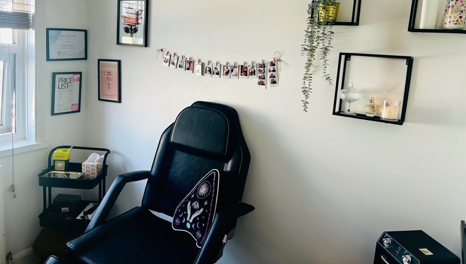 Chic piercing room at Durose Piercing, Portsmouth, England featuring a black chair and elegant wall decor.