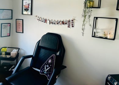 Chic piercing room at Durose Piercing, Portsmouth, England featuring a black chair and elegant wall decor.
